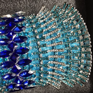 Dettaglio macro di strass marquise blu su una borsa da sera in metallo lucido
