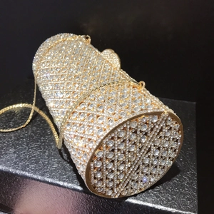 Goldene zylindrische Abendtasche mit funkelnden Kristallen und einer Metallkette besetzt