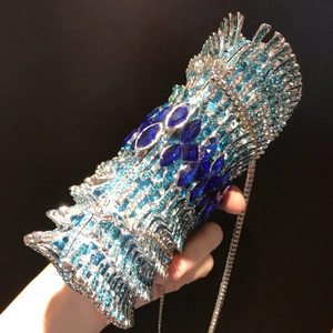 Dettaglio della pochette da sera in strass con motivo gemma blu e catena d'argento