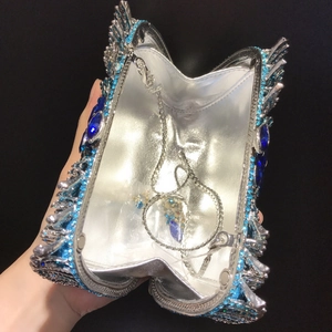 Vista macro della borsa da sera con strass blu, telaio in metallo e catena argentata