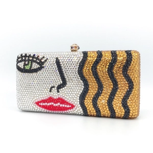 Sparkling crystal evening clutch with abstract face design and emerald green eye