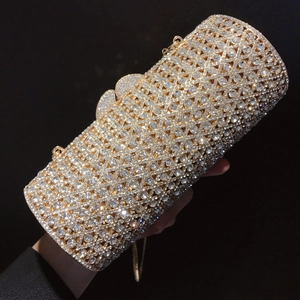 Detail der zylindrischen Abendtasche mit goldenem Metallrahmen und glitzernden Strasssteinen