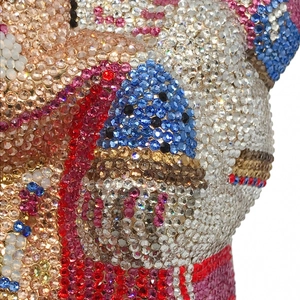 Détail macro de cristaux multicolores posés main sur une pochette de soirée luxe éléphant