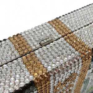 Macro shot of striped rhinestone evening clutch featuring sparkling crystals and silver frame