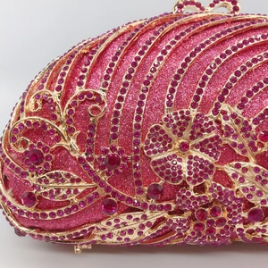 Pink evening clutch bag with golden hollow metal flower patterns and ruby rhinestones