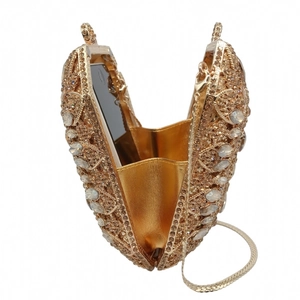 Macro scatto di una borsa da sera a forma di cuore con finiture dorate e strass