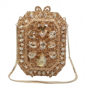 Dettaglio macro della borsa clutch dorata con cristalli centrali a forma di goccia