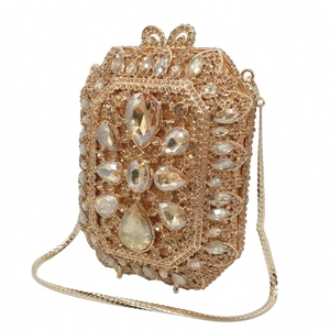 Dettaglio della pochette da sera color champagne con fiori di cristallo e chiusura a fiocco