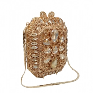Dettaglio della pochette da sera dorata con strass scintillanti e pietre a goccia