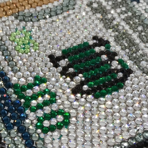 Macro view of tight crystal inlay craftsmanship on a multicolor diamond evening clutch