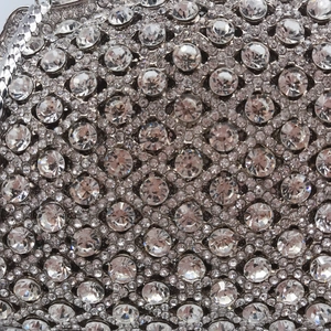 Exquisite silver evening clutch bag featuring intricate hollow metal and crystal inlay