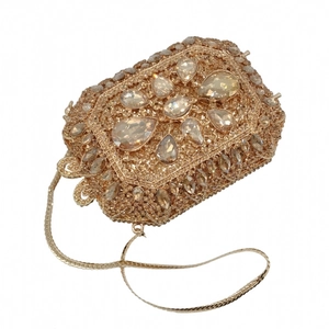 Dettaglio di pochette da sera dorata di lusso con strass e catena in metallo