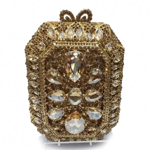 Dettaglio degli strass champagne e cristalli a goccia sulla borsa da sera dorata