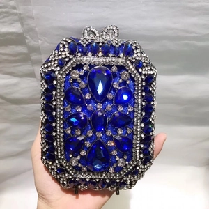 Dettaglio della pochette da sera blu reale con strass a goccia e chiusura a fiocco