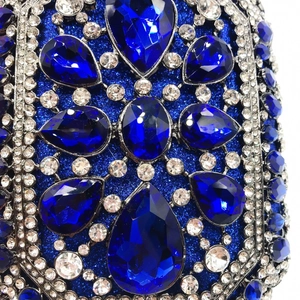 Dettaglio ravvicinato di cristalli a goccia blu reale e strass bianchi su borsa da sera