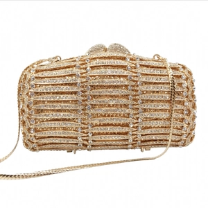 Detailed close-up of golden evening clutch bag featuring shimmering rhinestones and chain
