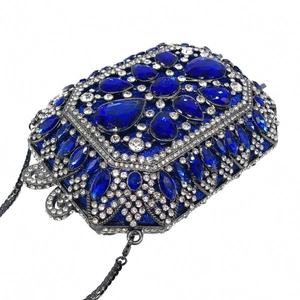 Dettaglio di una lussuosa pochette da sera con cristalli blu navy, catena argento e chiusura