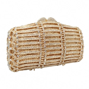 Close-up of golden hollow metal evening bag with luxury rhinestone wave pattern