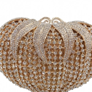 Detailed close-up of sparkling crystals and golden metal leaf clasp on luxury evening clutch