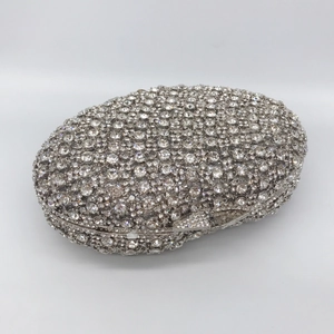 Détail d'une pochette de soirée ovale argentée ornée de strass et d'un fermoir métallique