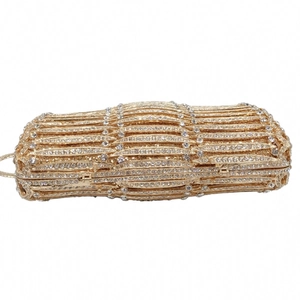 Macro view of golden rhinestones and hollow metal stripe texture on the evening clutch