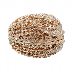 Macro shot of egg-shaped evening bag with gold metal base and glittering white rhinestones