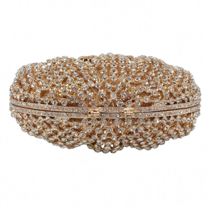 Macro shot of oval evening clutch with shimmering crystals and gold metal frame