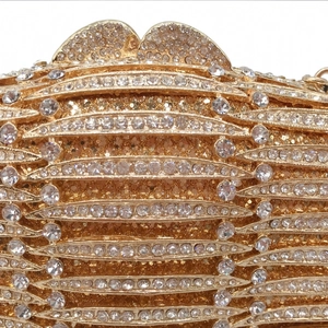 Macro shot of gold dinner clutch featuring dense rhinestone inlay and wave metal frame