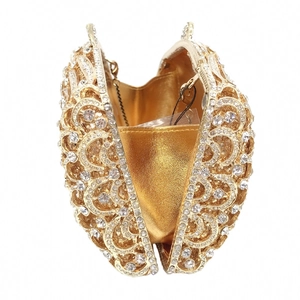 Detailed interior view of a luxury gold hollow-out evening clutch bag with rhinestones