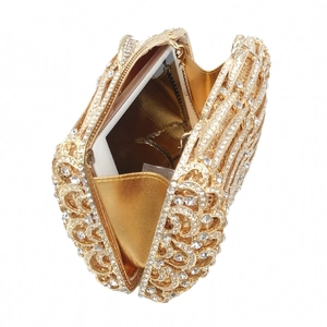 Golden hollow metal clutch with rhinestones showing interior capacity for a smartphone