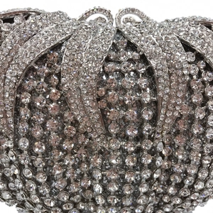 Macro view of silver hollow evening bag featuring radiant rhinestone shell pattern