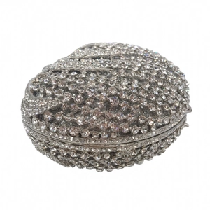 Macro view of crystal rhinestones and silver metal hinge on an oval evening clutch bag
