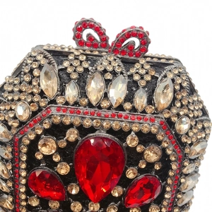 Dettaglio di strass champagne e pietre rosse a goccia su una pochette da sera di lusso