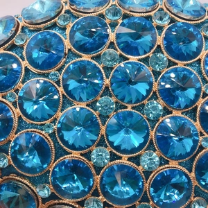 Luxurious evening clutch with blue crystals and gold braided metal texture details