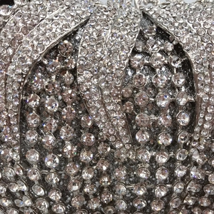 Macro shot of silver hollow-out evening bag with intricate sparkling crystal rhinestones