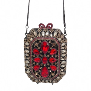 Dettaglio di pochette da sera di lusso con motivo floreale in cristallo rosso e strass