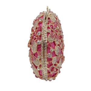 Detailed view of hollow out gold metal mesh and pink rhinestones on evening clutch bag