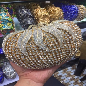Macro detail of luxury gold-tone metal evening clutch with shimmering crystal embellishments