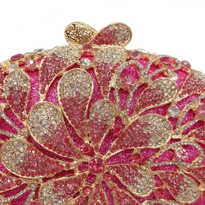 Close-up of rose pink evening clutch with floral rhinestone patterns and bow clasp