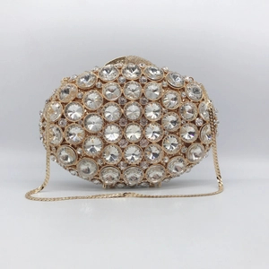 Detail of gold hollow evening bag encrusted with large sparkling crystals and chain