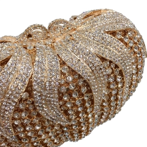 Macro detail of luxury gold evening clutch with densely set white rhinestones