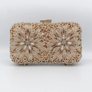 Pochette de soirée dorée en métal ajouré avec motif double fleur en strass sur fond blanc
