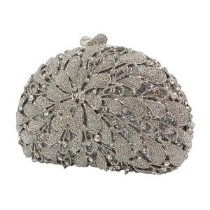 Close-up of silver rhinestone evening bag with floral metal frame and bow clasp