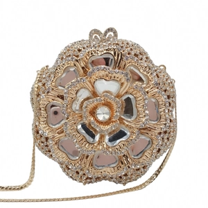 Close-up of golden floral evening clutch with intricate crystal rhinestones and gems