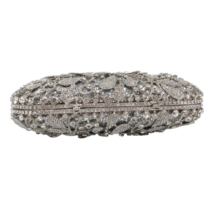 Detailed macro of silver evening clutch with intricate rhinestone leaf and flower patterns
