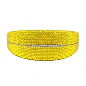 Macro detail of yellow crystal lemon clutch bag with silver metal hinge closure