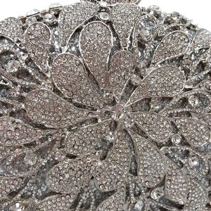 Macro detail of silver floral hollow-out evening clutch bag with sparkling rhinestones