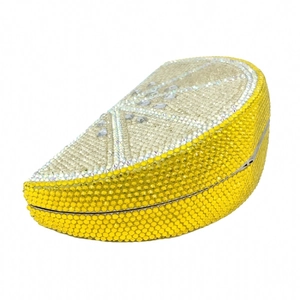 Macro view of crystal encrusted lemon shaped clutch bag with silver frame and snap clasp