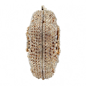 Detail of luxury evening clutch with shimmering white crystals and gold metal frame finish