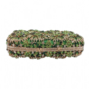 Detailed view of luxury evening clutch featuring green floral rhinestones and gold metal frame